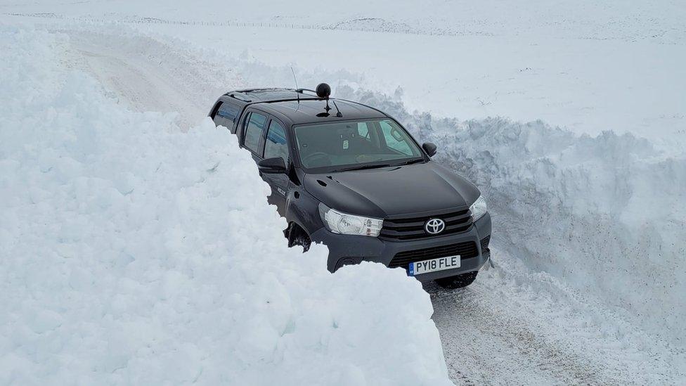 Truck passing snow drifts on Cawdor Estate