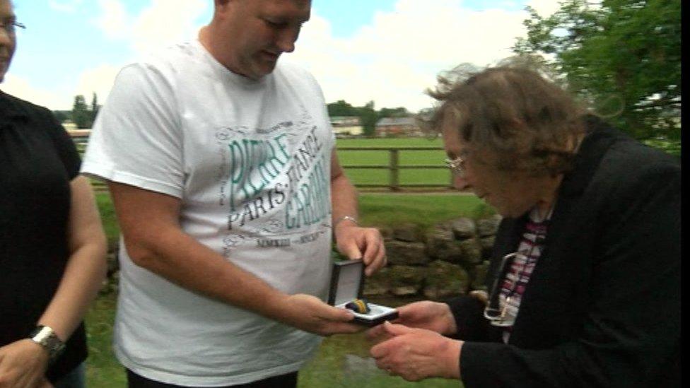 Chris Jeffreys presents the war medal he found to the recipient's daughter-in-law Moira Boaden