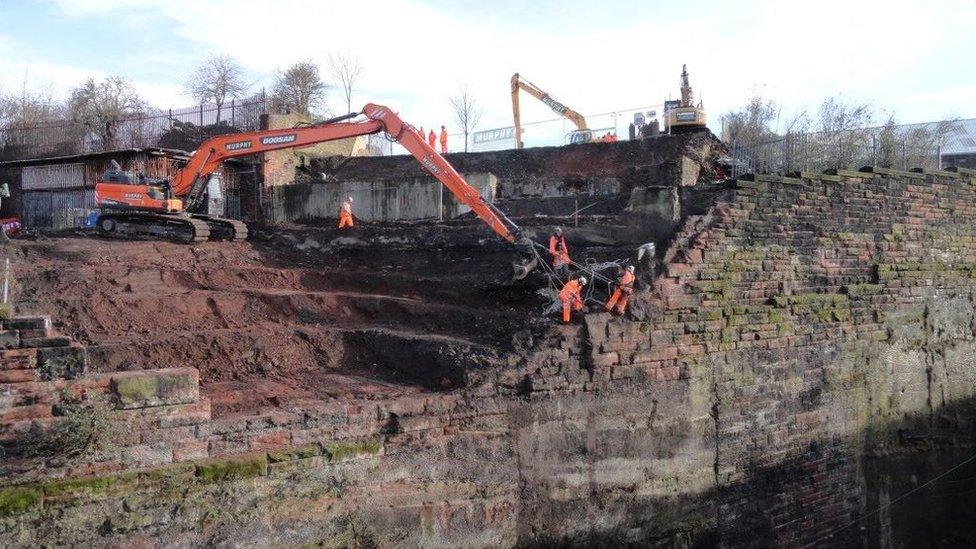 Workers fixing collapsed wall