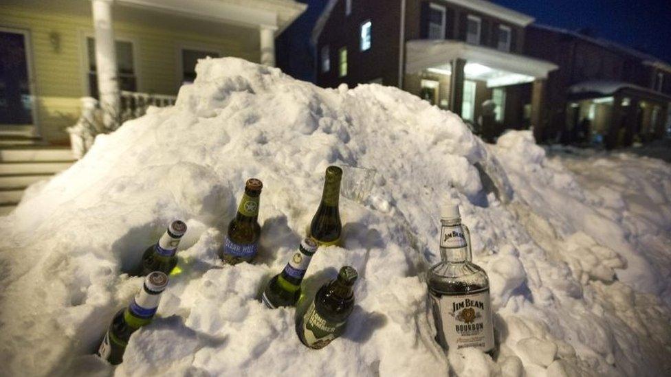 Discarded alcohol bottles sit in the snow in the Friendship Heights neighbourhood of Washington