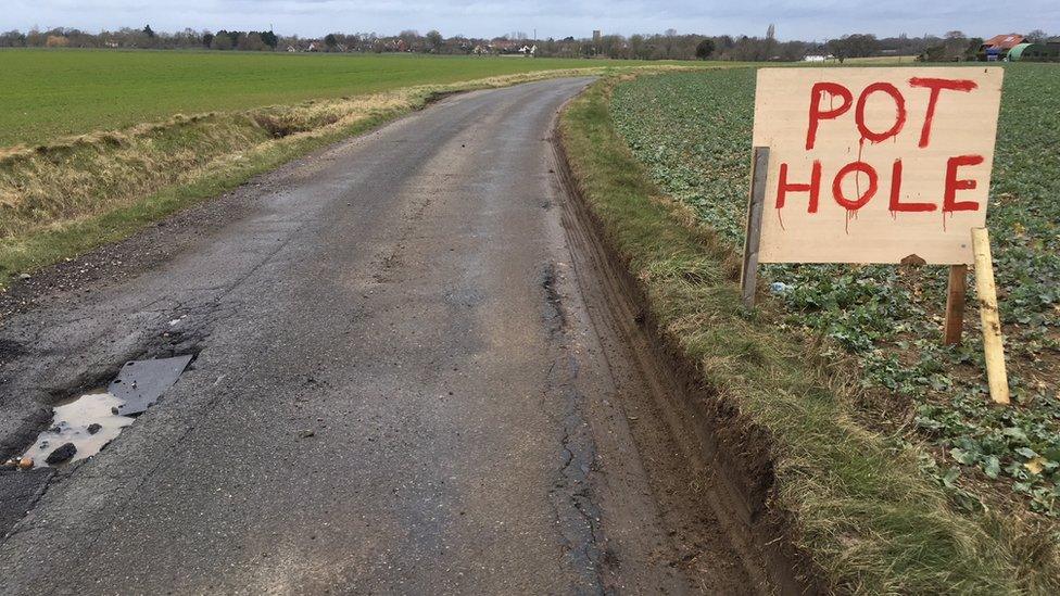 The hand-painted pothole sign