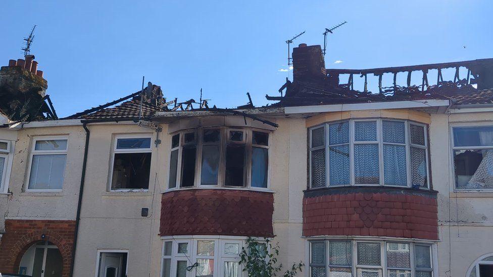 House with burned-out roof which has collapsed