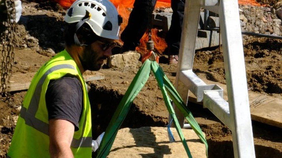 Stone coffin being unearthed