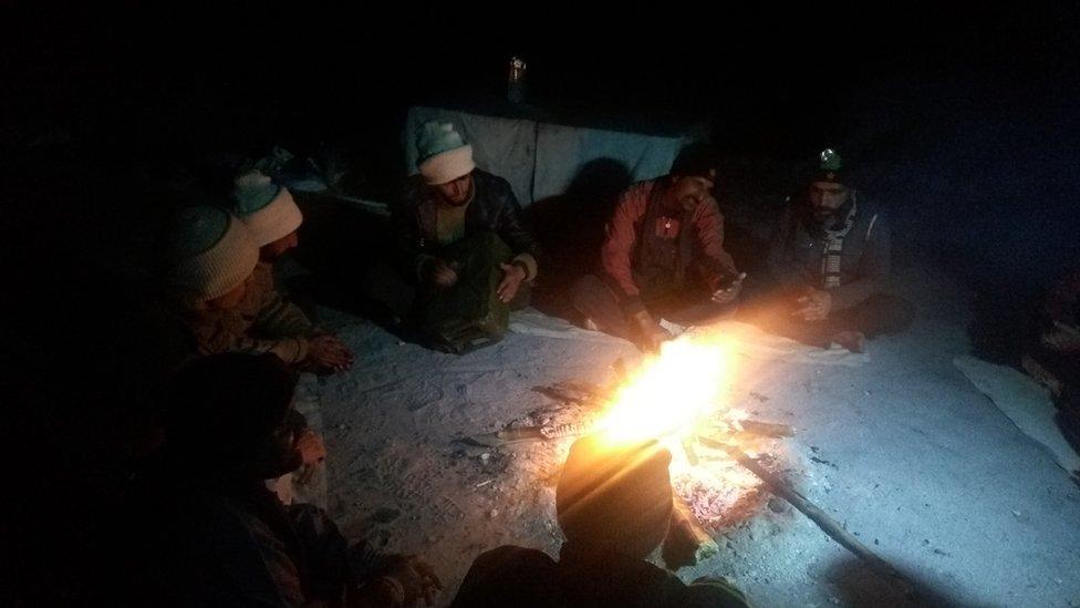 Soldiers round a fire at a post in Siachen