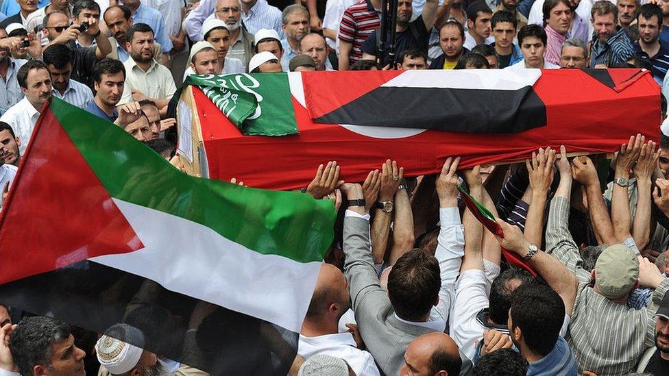 A coffin draped in a Turkish and a Palestinian flag is carried along during a funeral service for activists killed on Mavi Marmara, in Istanbul on 3 June 2010