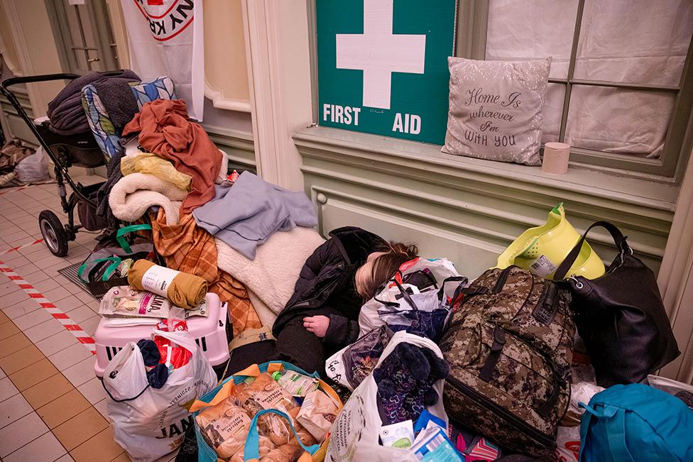 An exhausted refugee sleeps inside the train station