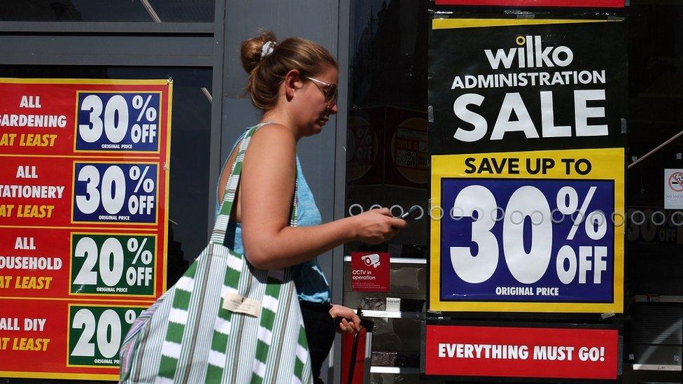 Woman walking past Wilko store