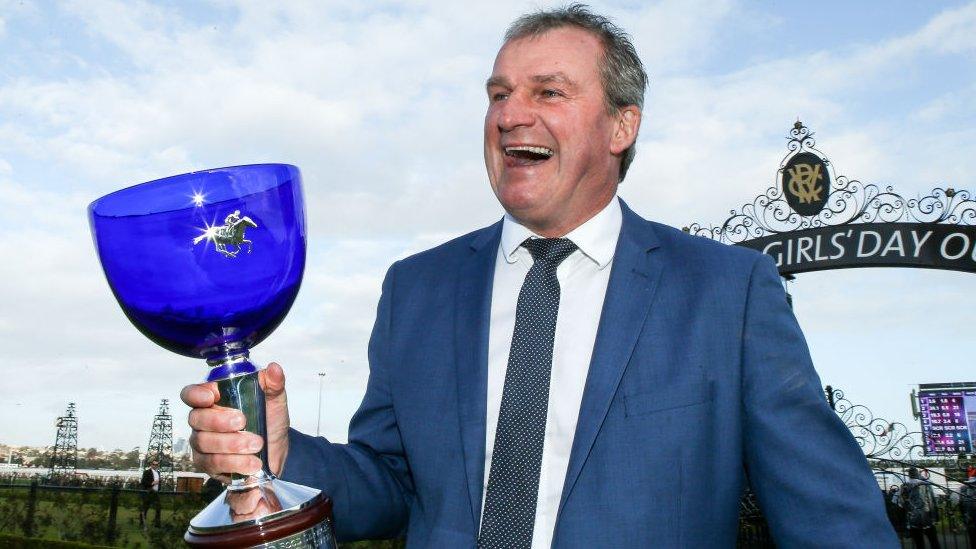 Horse trainer Darren Weir poses with a trophy