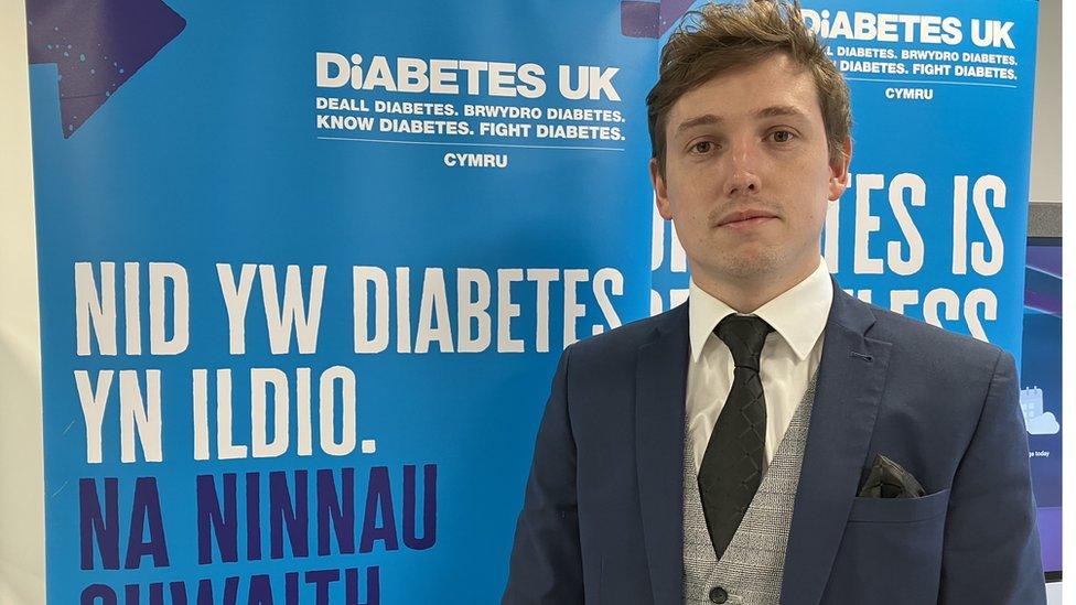 Mathew Norman o flaen poster 'Nid yw diabetes yn ildio'