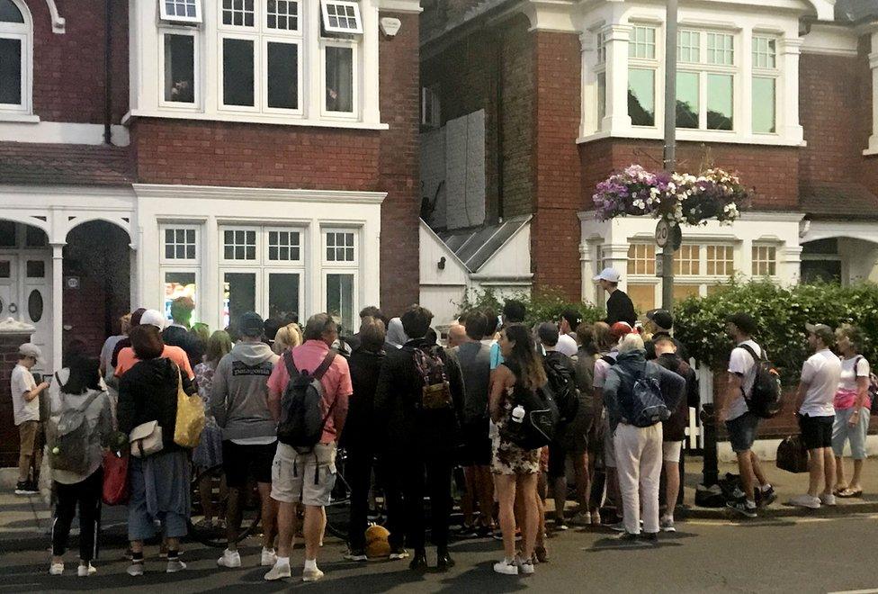 People watch the World Cup through a person's front room window