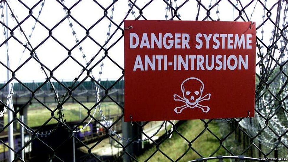 A danger sign on the security fence at Sangatte