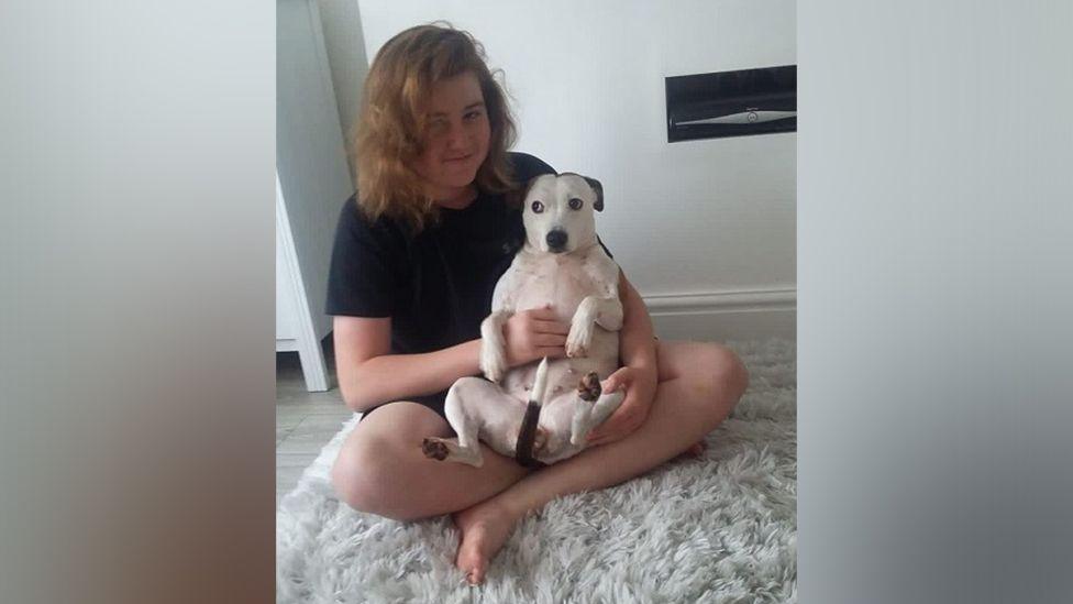 Ellis Cox holding a black and white dog