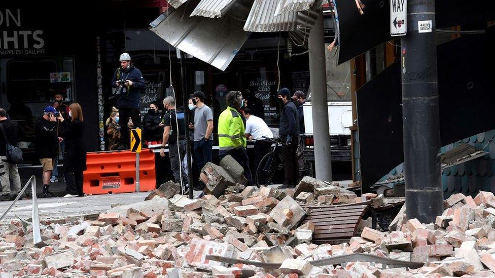 Rubble on a street next to bystanders