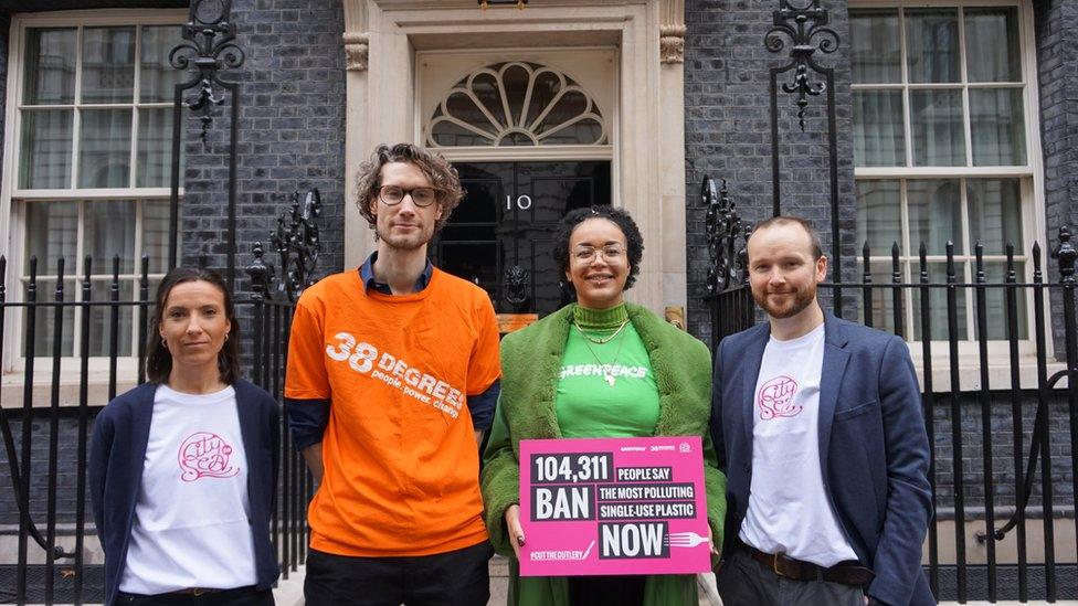 Four people in brightly coloured outfits outside No.10 Downing Street