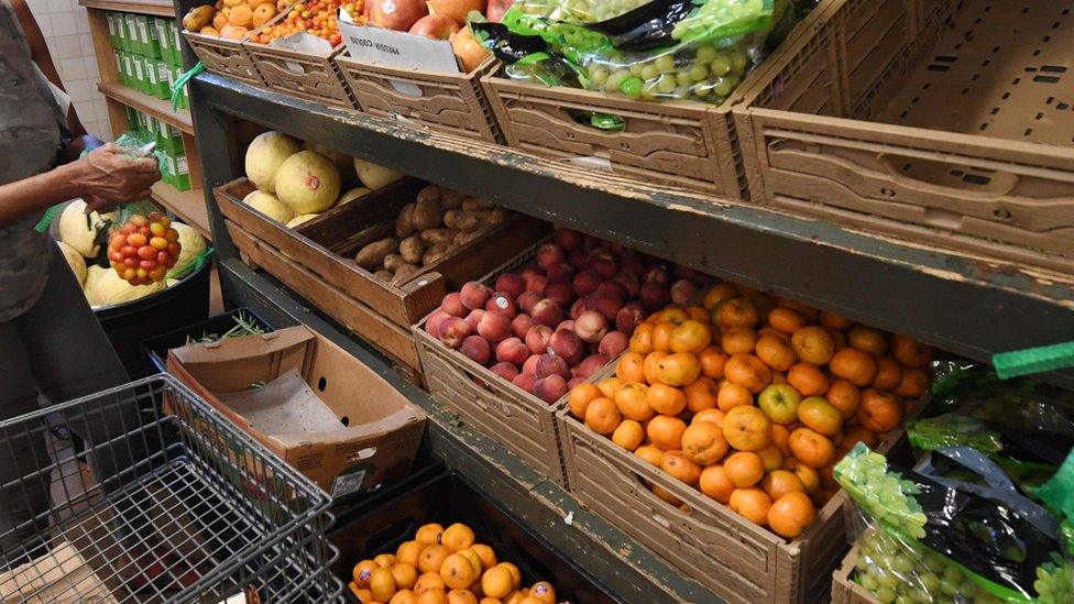 Woman at food bank choosing produce, Los Angeles (24 July 2019)