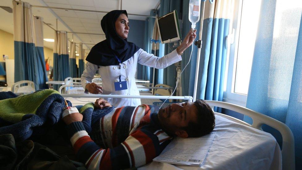 An Iranian nurse tends to a man wounded in a stampede in the southeastern city of Kerman in January 2020.