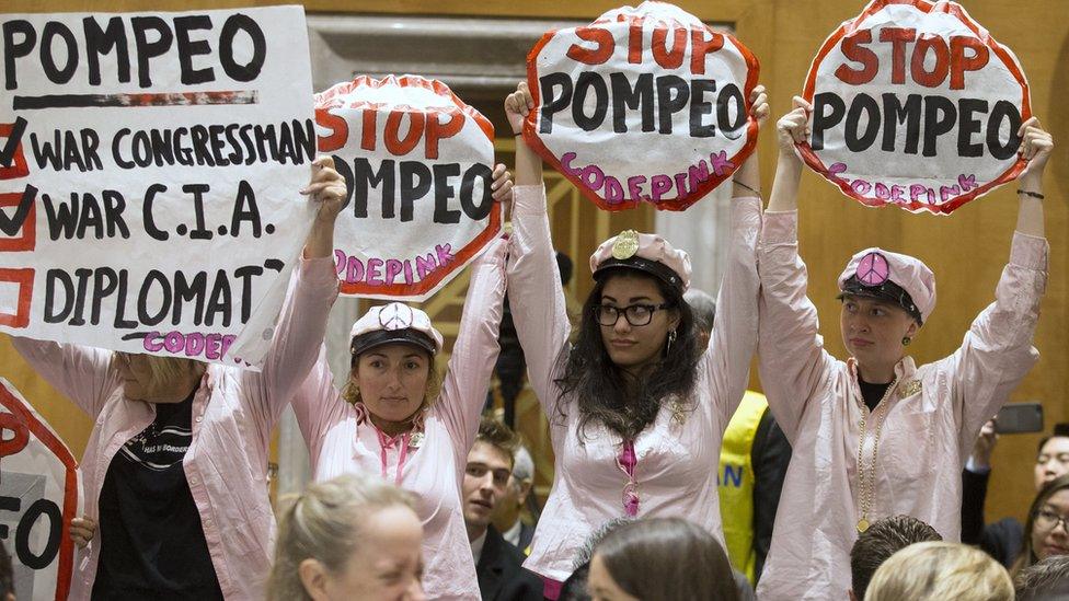 Protesters hold signs opposing CIA Director Mike Pompeo (not pictured) before the start of the Senate Foreign Relations Committee hearing