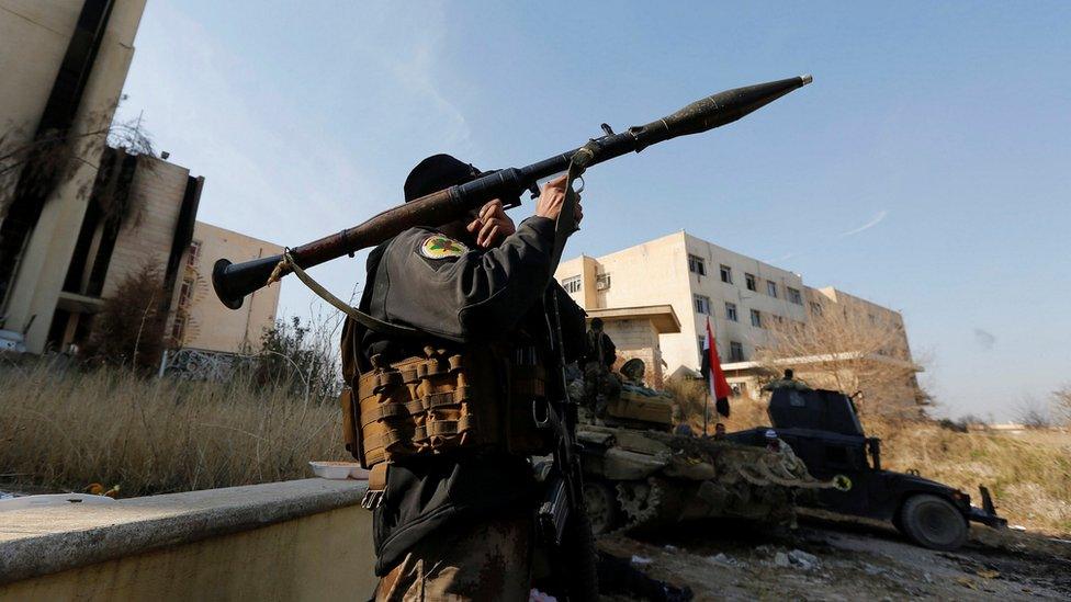 A member of Iraqi Special Operations Forces (ISOF) carries a rocket launcher at the University of Mosul.