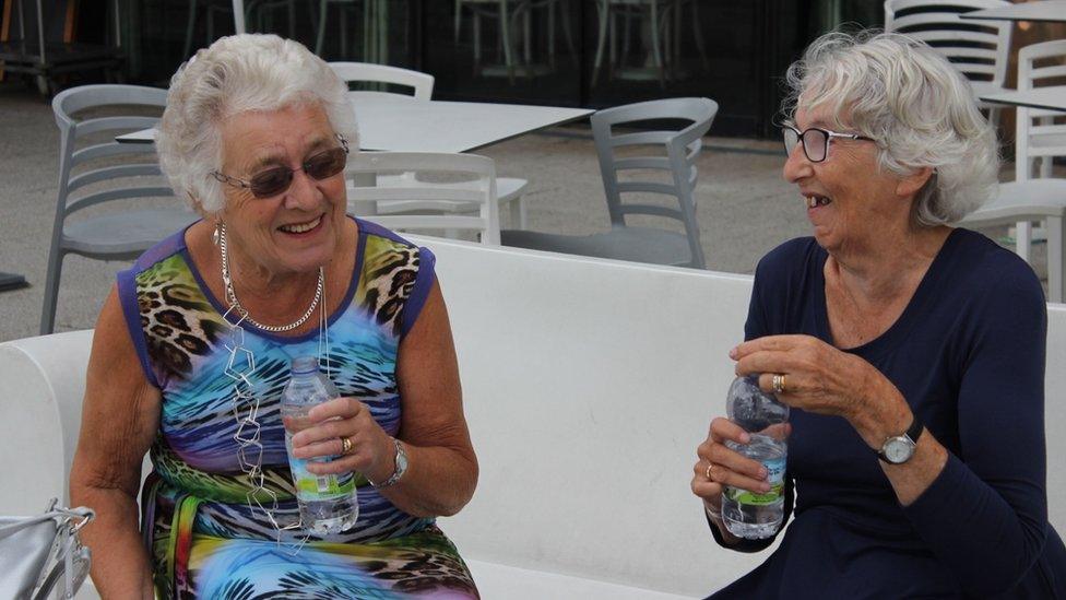 Glenys a Myra o'r Wyddgrug yn sgwrsio cyn mynd ir Pafiliwn i fwynhau'r cystadlu ac yn mwynhau'r mes heb fwd. Sandalau nid wellies eleni! // Friends from Mold enjoying the Eisteddfod