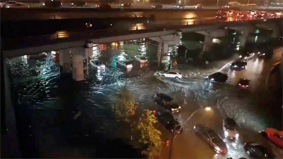 Cars driving on flooded streets