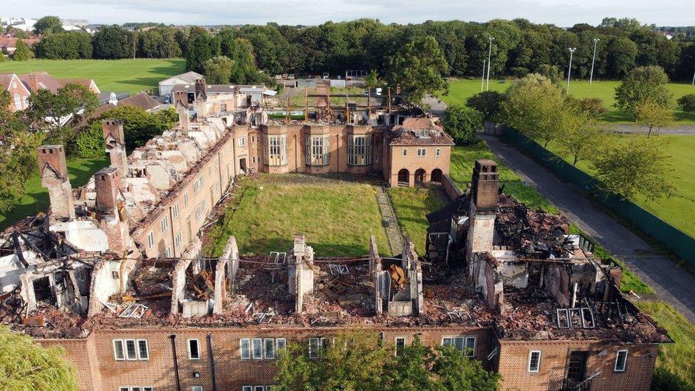 An aerial image of Henderson Hall after the fire. Its roof has been completely destroyed. Rubble has been left on the floor of the exposed upper floors.