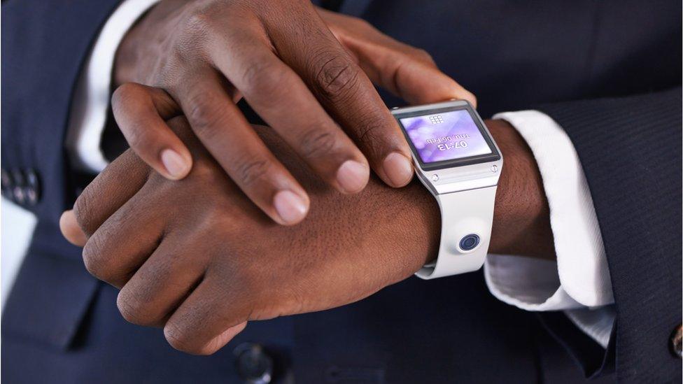 A man looking at a digital watch