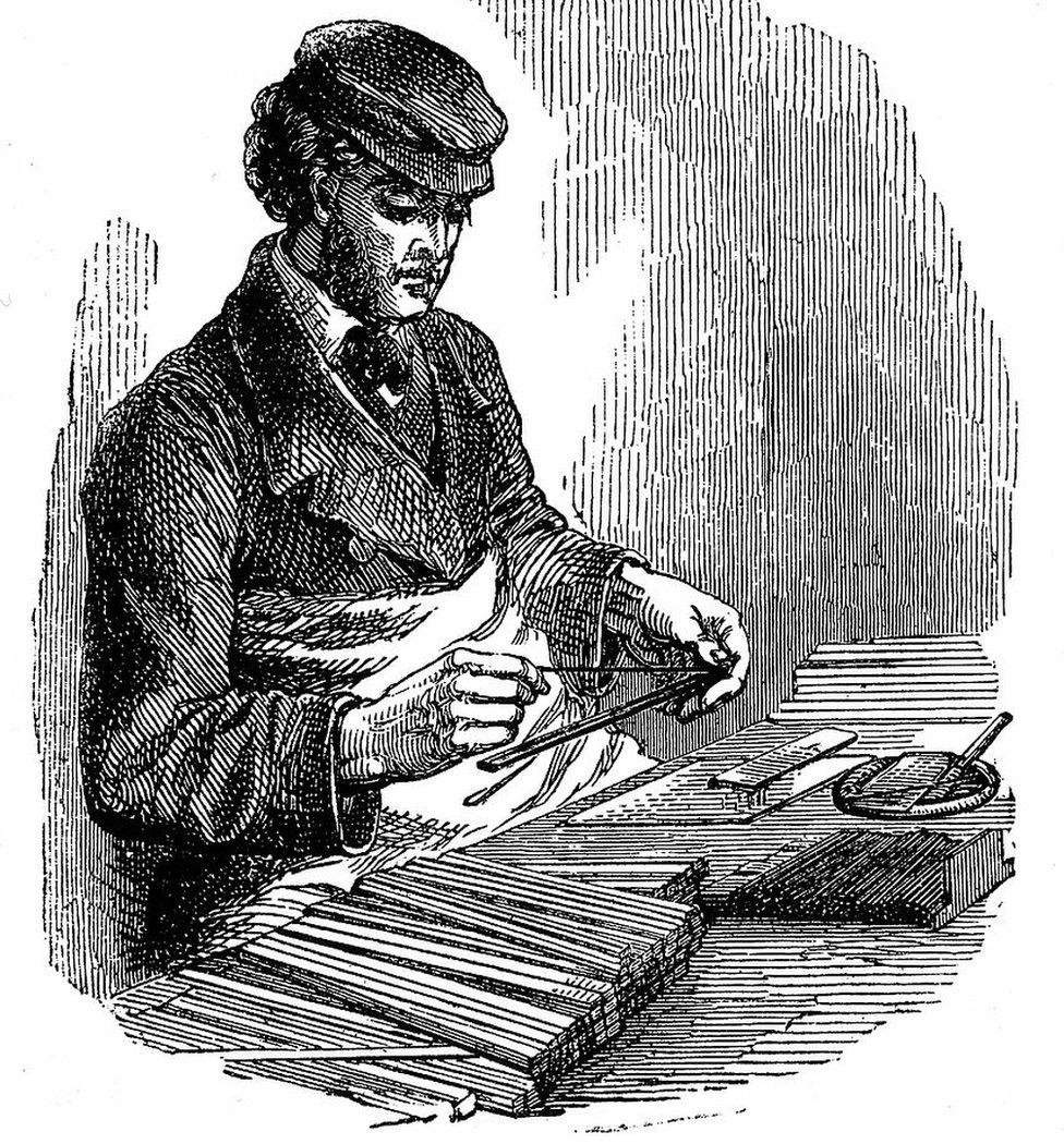 A man inserts graphite between strips of cedarwood in an 1872 engraving