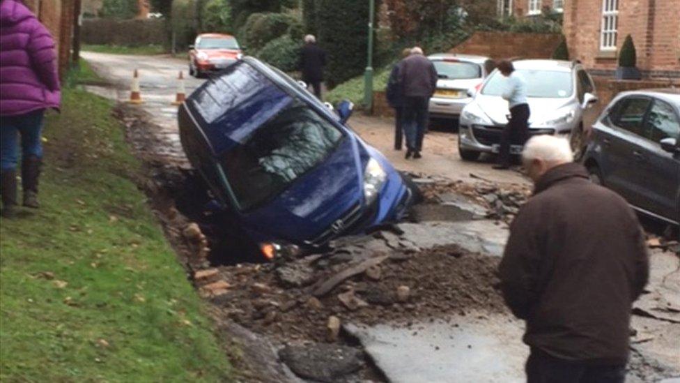 Car in a sinkhole created by a burst water main