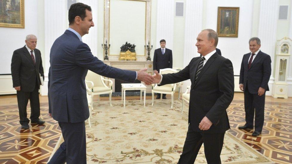 Russian President Putin shakes hands with Syrian President Assad during a meeting at the Kremlin in Moscow