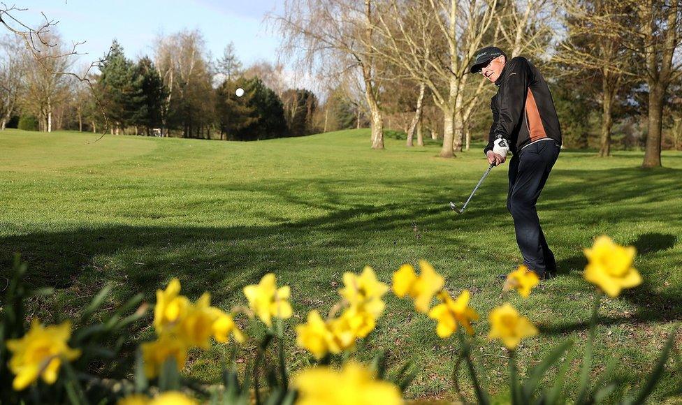 A golfer putts a ball