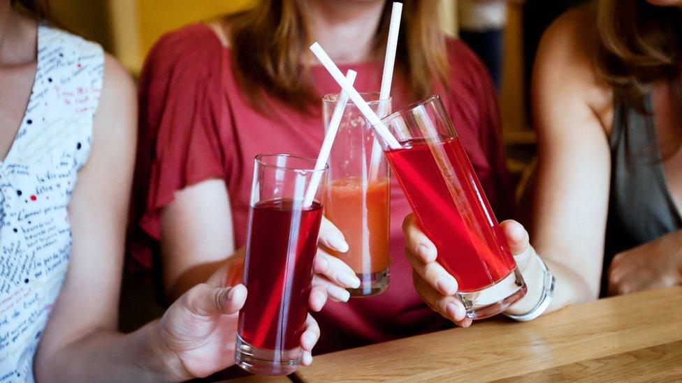 Women holding drinks