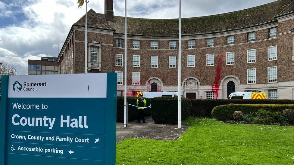 Image of County Hall in Taunton. There is red spray paint on the outside of the building