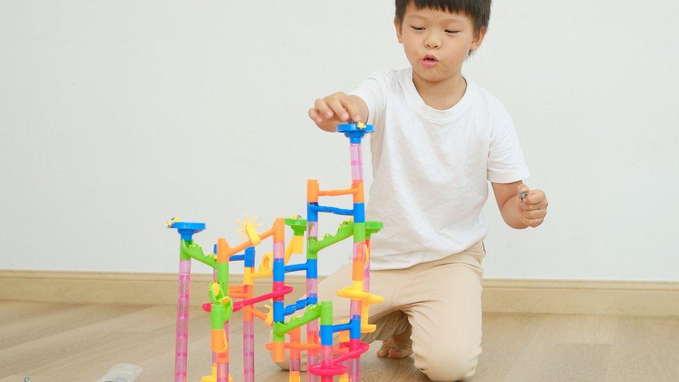 Young boy plays with a marble run