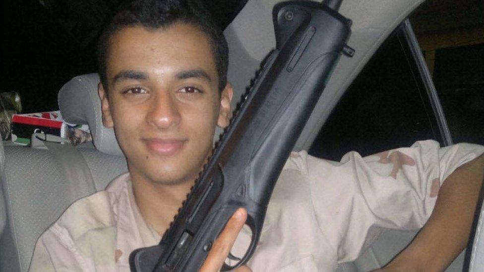 Ismail Abedi holding a gun