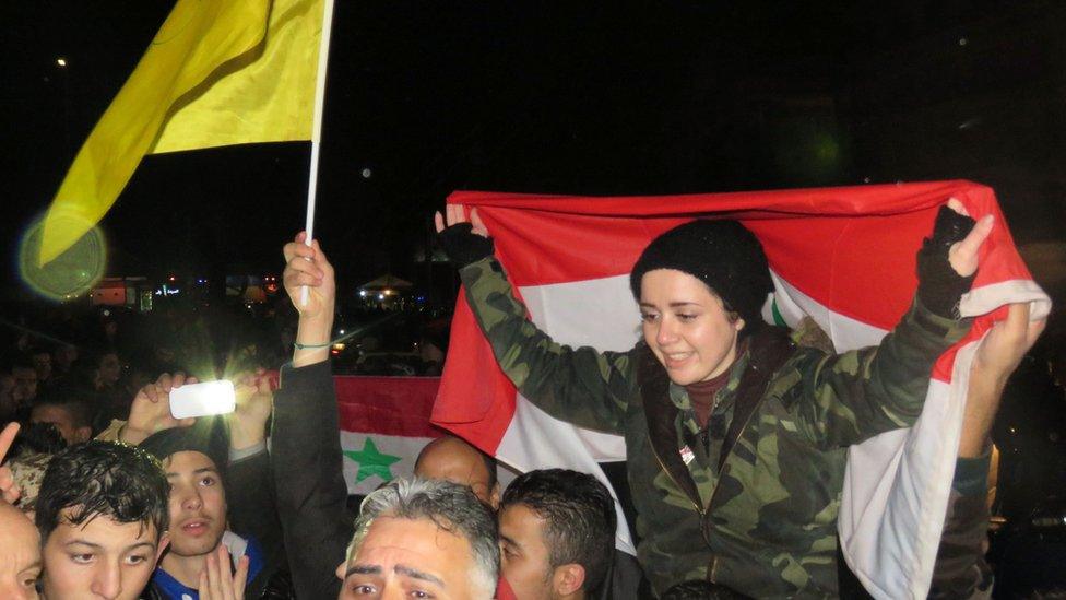 Syrians celebrate in a government-held part of Aleppo on 12 December 2016