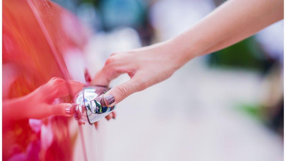 Woman opening car door