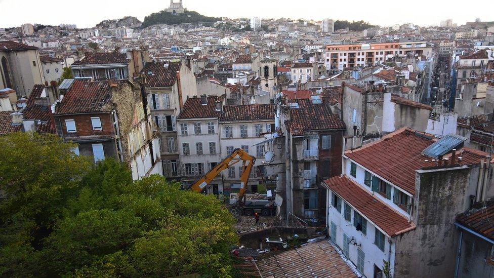 A view taken on November 6, 2018 from a neighbouring building shows workers removing rubble where two buildings collapsed, resulting in at least two people injured, in Marseille