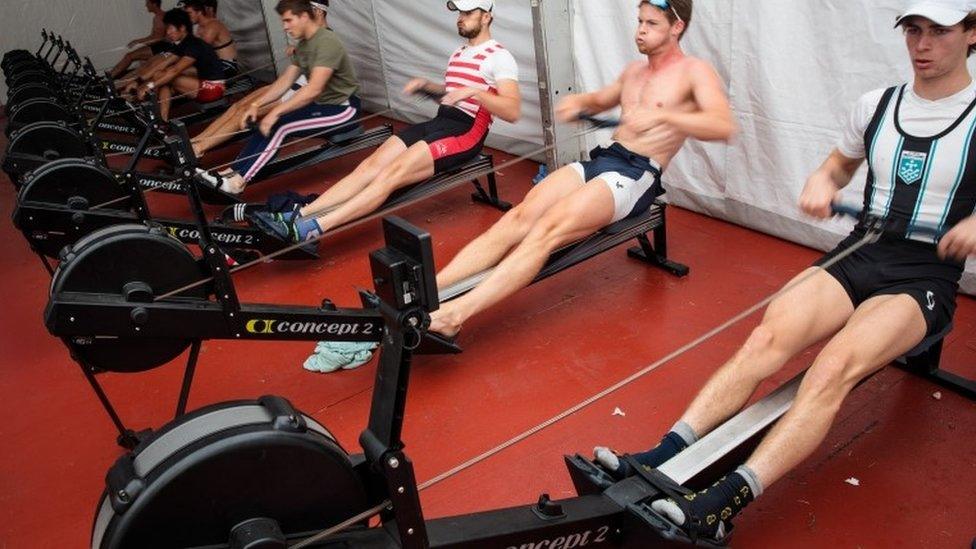 Competitors warm up on rowing machines on site ahead of their races