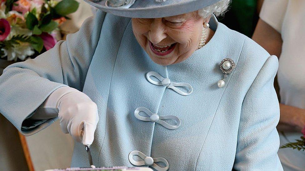 The queen cutting a cake