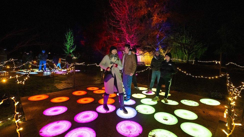 People standing on a platform of illuminated circles