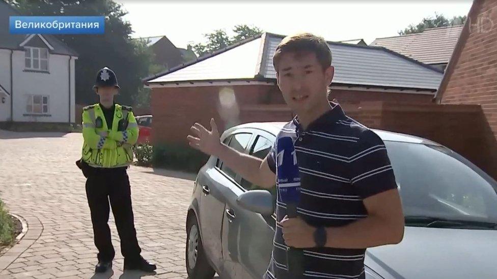 Russian TV reporter pointing at a British policeman