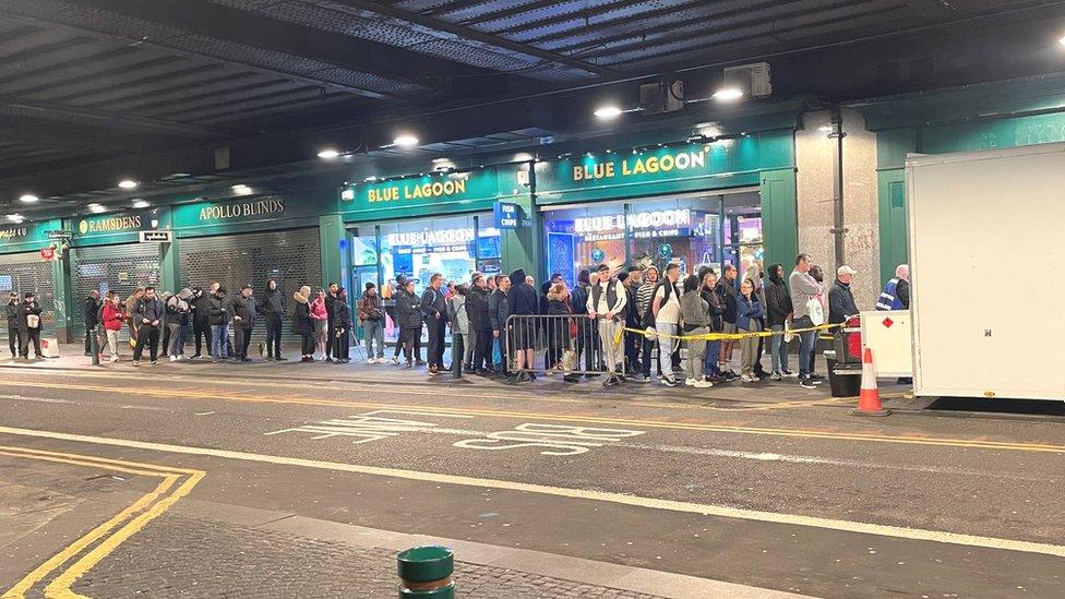 People queuing for donations under Central Bridge