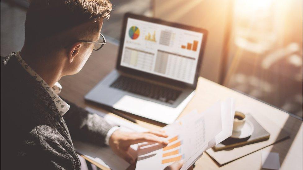 Man looking at accounts on screen