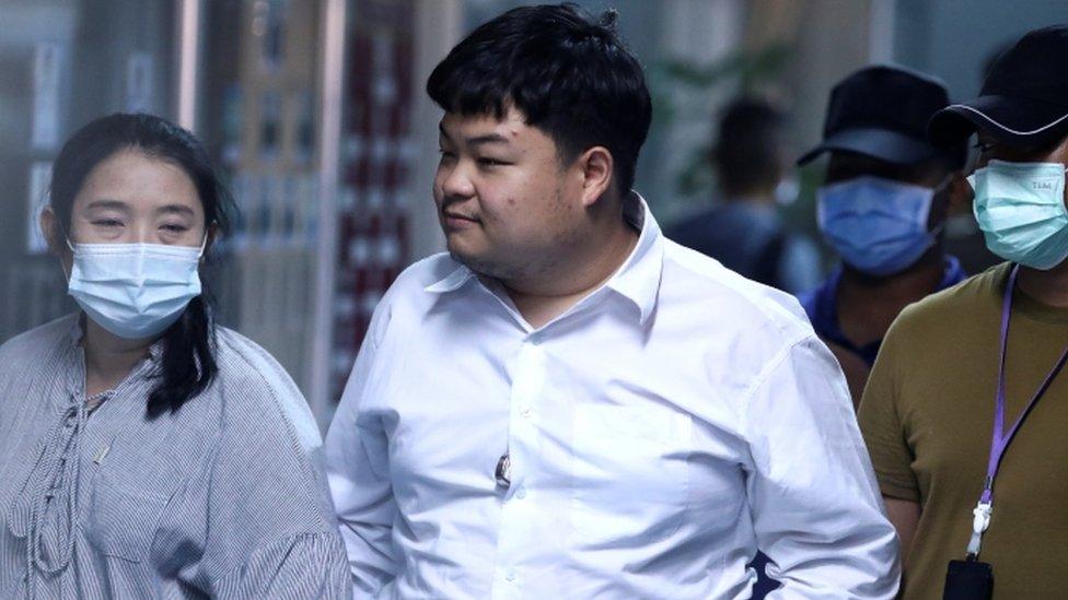 Parit Chiwarak walks with his mother at the police station after being arrested on 14 August