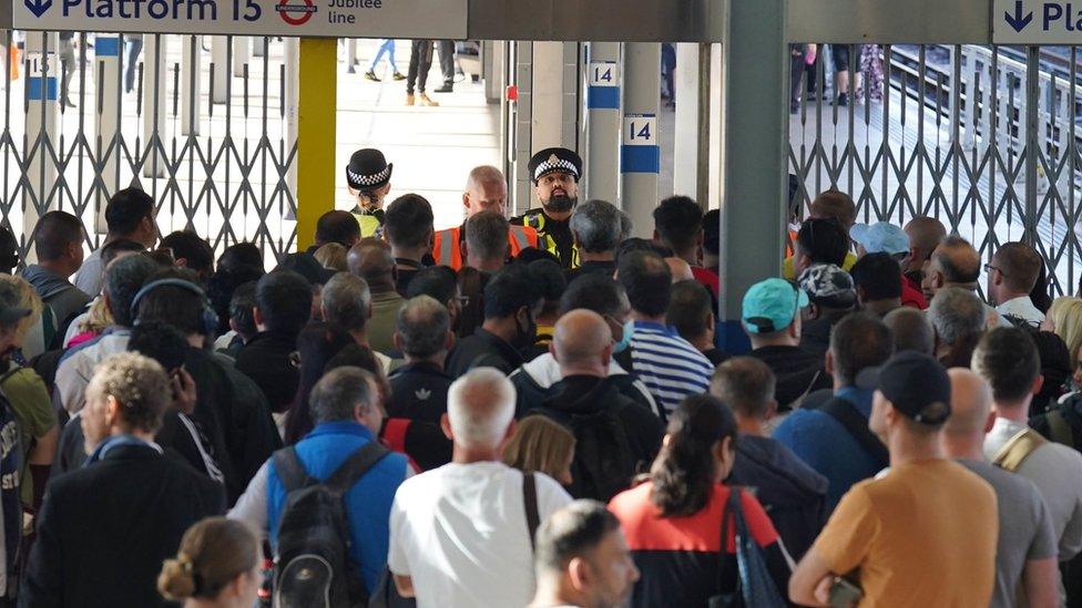 Passengers wait for Stratford station to open in London