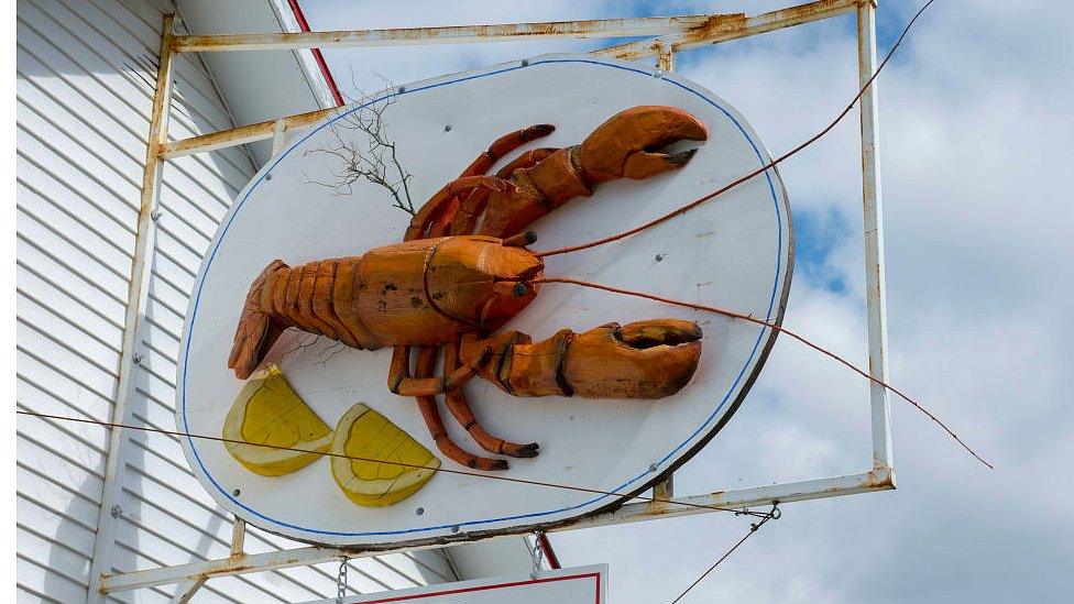 Seafood restaurant with wooden lobster sign in Baddeck, Nova Scotia