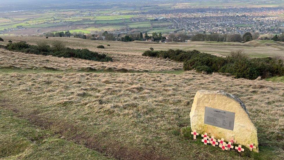 The memorial erected on Cleeve Hill, made of stone from the nearby Common quarry. There are small crosses with poppies laid at its base.