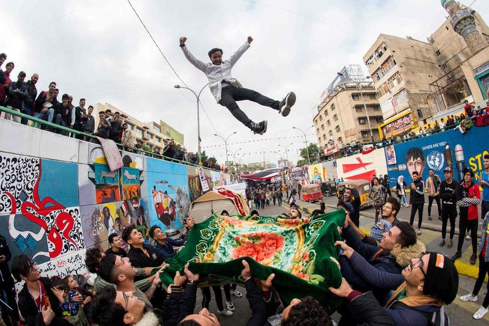 A young Iraqi protester is blanket-tossed into the air by fellow demonstrators as anti-government rallies continue in Tahrir Square in the capital Baghdad.