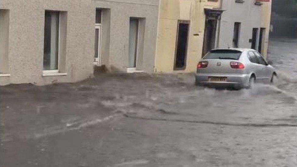 car driving through flooded street