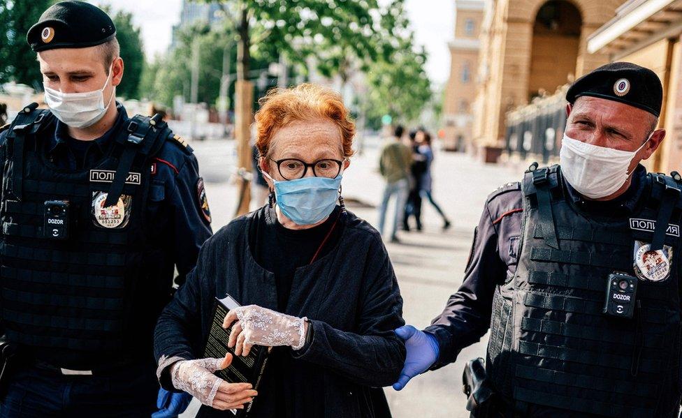 Photojournalist Victoria Ivleva is led away by police outside the interior ministry in Moscow